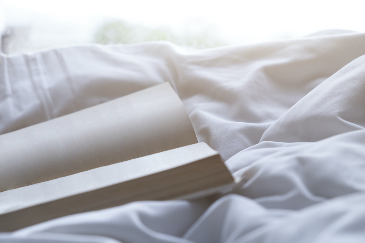 Empty page book on soft bed in the morning.